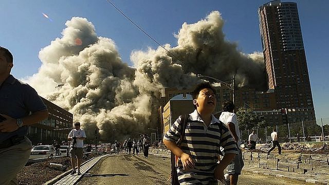 People run away as the North Tower of World Trade Center collapses after a hijacked airliner hit the building September 11, 2001 in New York City.