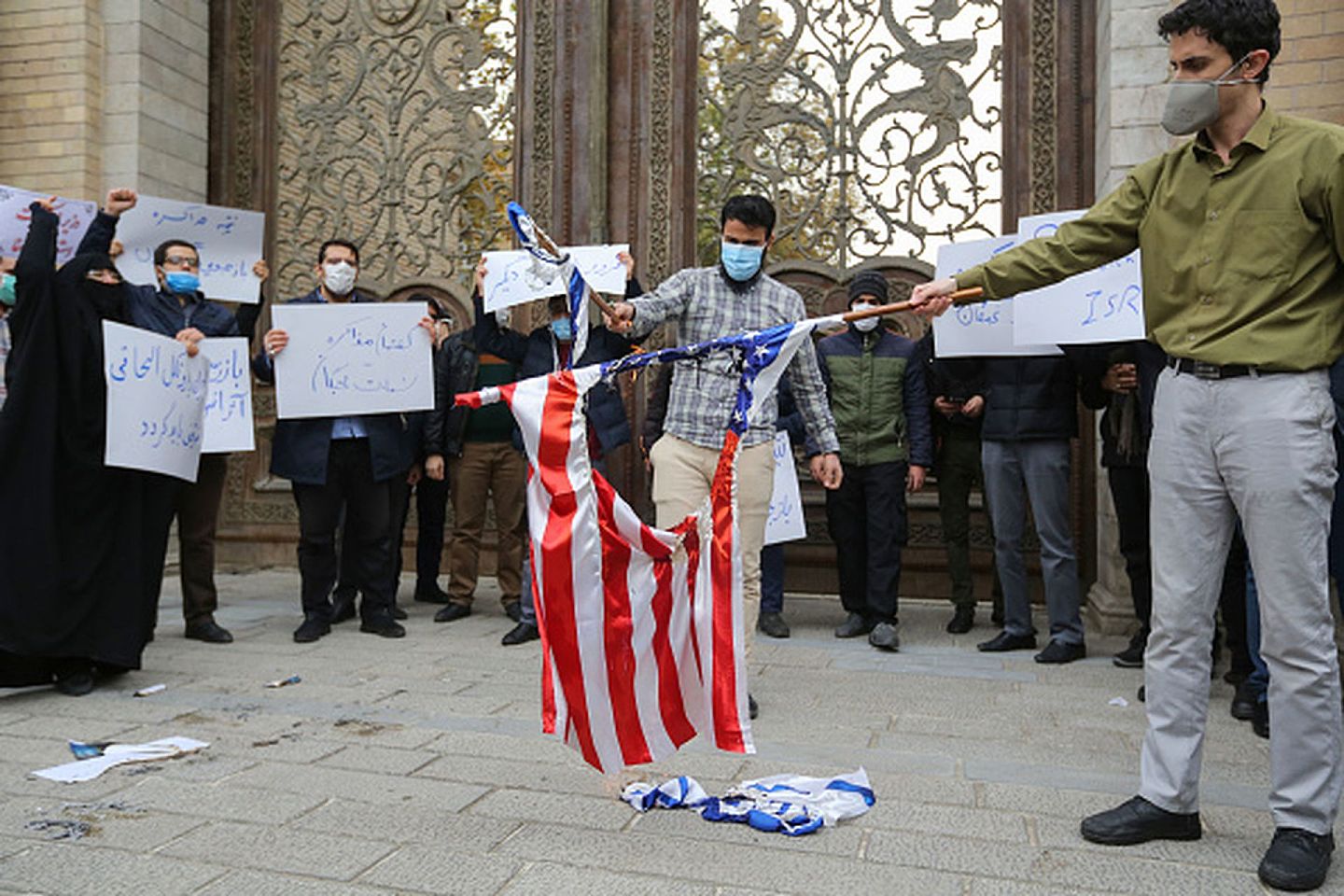 2020年11月28日，伊朗巴斯基军事学院的学员们在伊朗外交部大楼前举行集会示威，抗议美国与以色列对顶级核专家法克里扎德（Mohsen Fakhrizadeh）的暗杀劣行，图为示威学员焚烧美以国旗。（Getty）