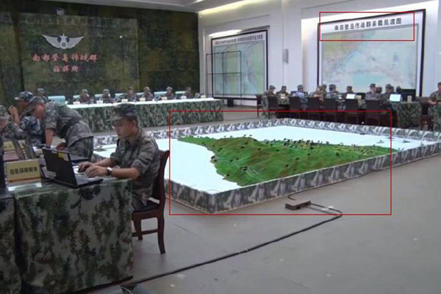 解放军内部披露的针对台湾的演习照。图中红框即为台湾地形沙盘。（中国央视截图）