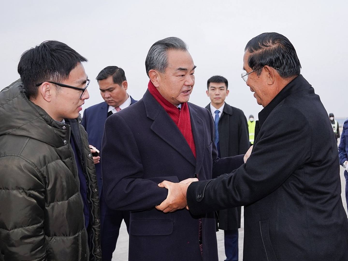 北京时间2020年2月5日下午，中国国务委员兼外交部长王毅（中）前往北京首都国际机场迎接来访的柬埔寨首相洪森。（新华社）