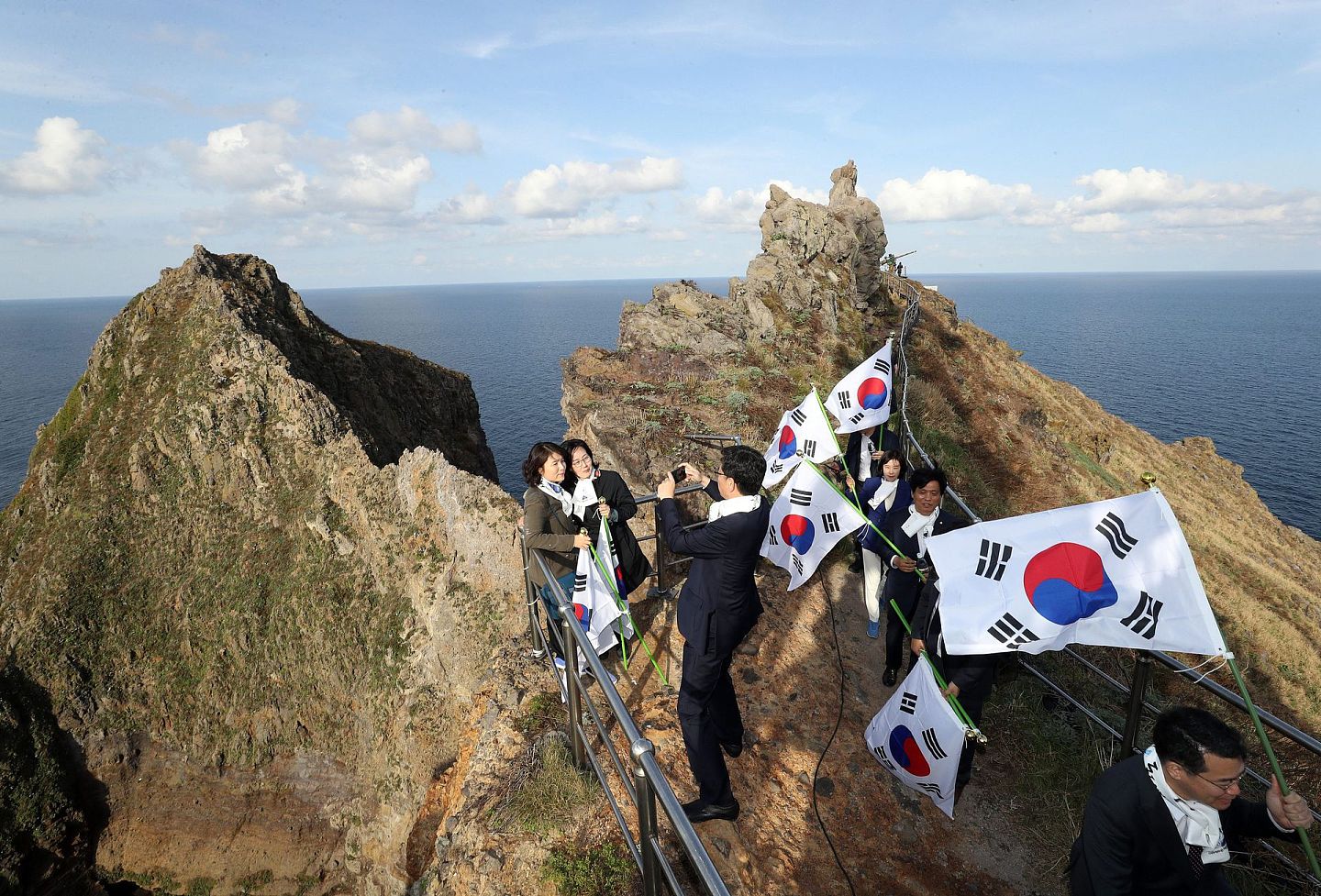 当地时间2018年10月22日，韩国国会教育委员会所属议员登韩日争议岛屿（日本称“竹岛”），并手举太极旗合影留念。10月25日是韩国“独岛日”。（视觉中国）
