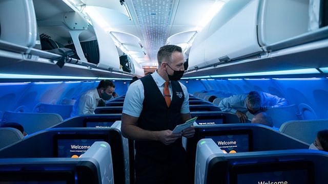 美国纽约肯尼迪国际机场一架捷蓝航空往英国伦敦航班上空勤人员与乘客交谈（11/8/2021）