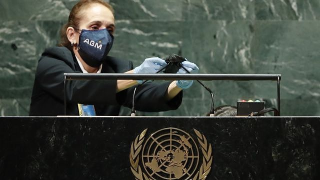 A United Nations employee cleans the microphones at the podium after Brazil's President Jair Bolsonaro spoke and before the start of U.S. President Joe Biden's address the 76th Session of the U.N. General Assembly on September 21, 2021 at U.N. headquarters in New York City