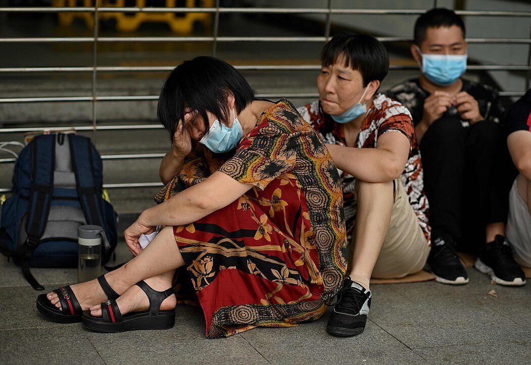 一名女子在公司深圳总部外抽泣。中国各地的恒大办事处都发生了抗议活动。