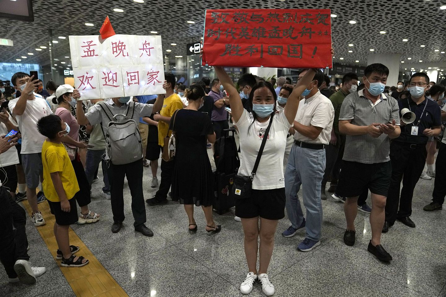 2021年9月25日，孟晚舟的支持者们聚集在深圳宝安国际机场，举着标语庆祝她的回归。（AP）