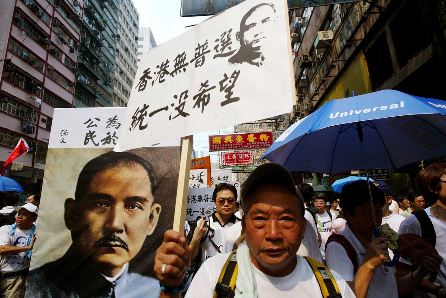 2004年7月1日，香港游行队伍中，有人举起绘有孙中山肖像的示威道具，要求香港落实普选。（Reuters）