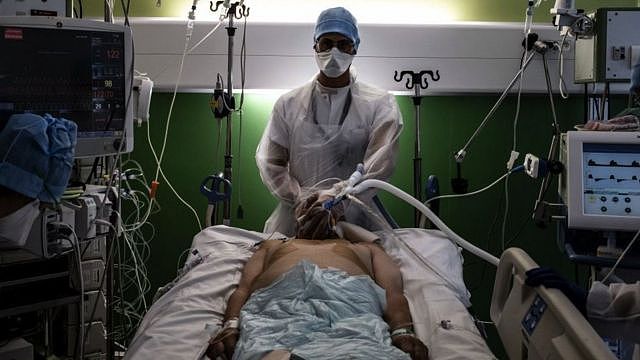 A doctor takes care of a patient infected with Covid-19 in the intensive care unit of Lyon-Sud hospital in Pierre-Benite, on September 8, 2021