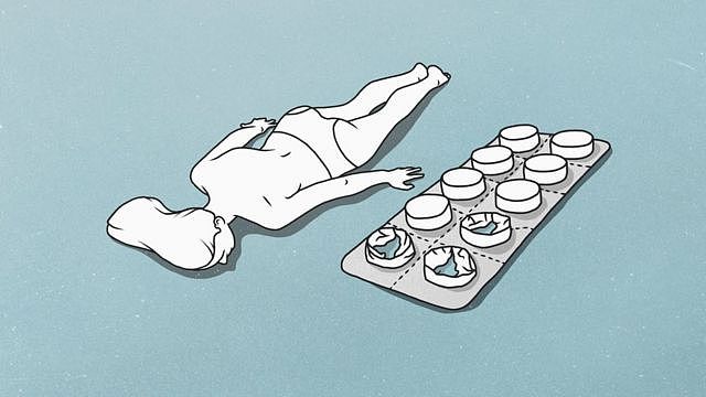 A female figure lying down next to a giant blister pack of tablets