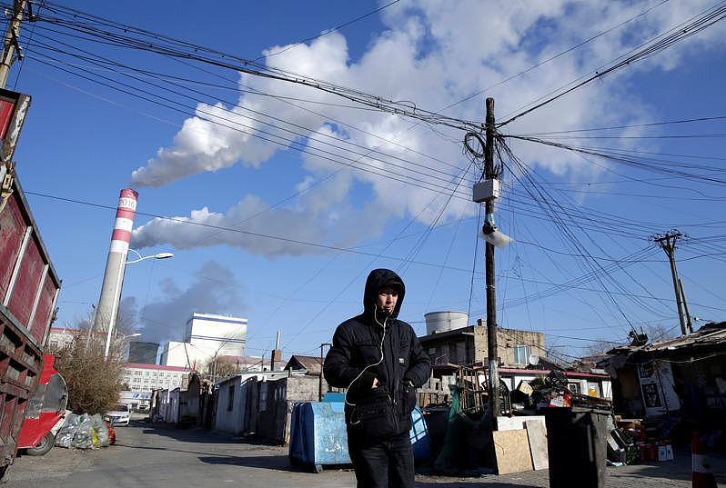一名男子行经中国东北黑龙江省哈尔滨市的燃媒厂。（路透）
