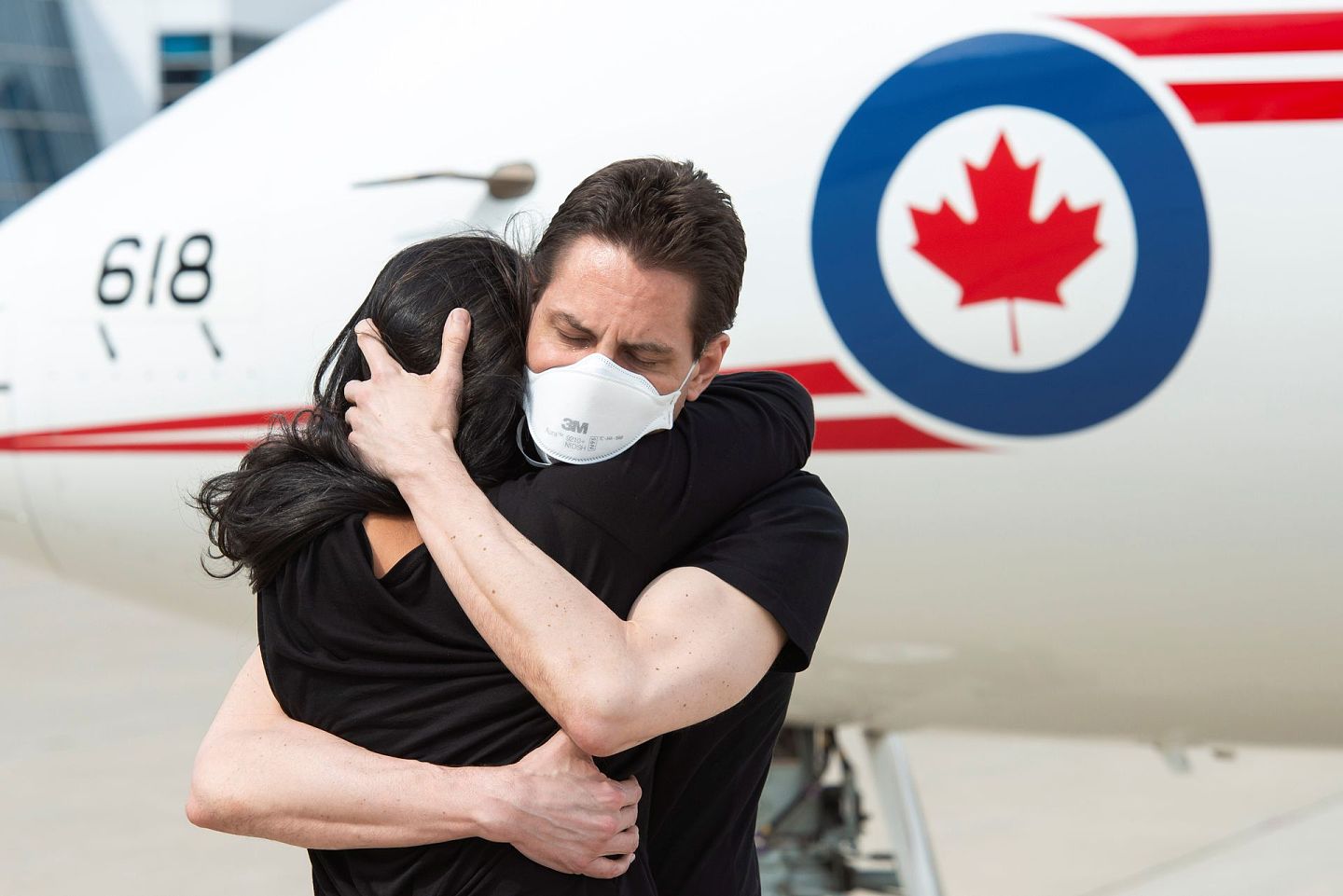 在华被拘的加拿大公民康明凯及斯帕弗2021年9月24日获释后，25日乘飞机返抵加拿大卡加利。图为康明凯乘空军飞机转飞抵达多伦多皮尔森国际机场下机后与妻子深深拥抱。（Reuters）