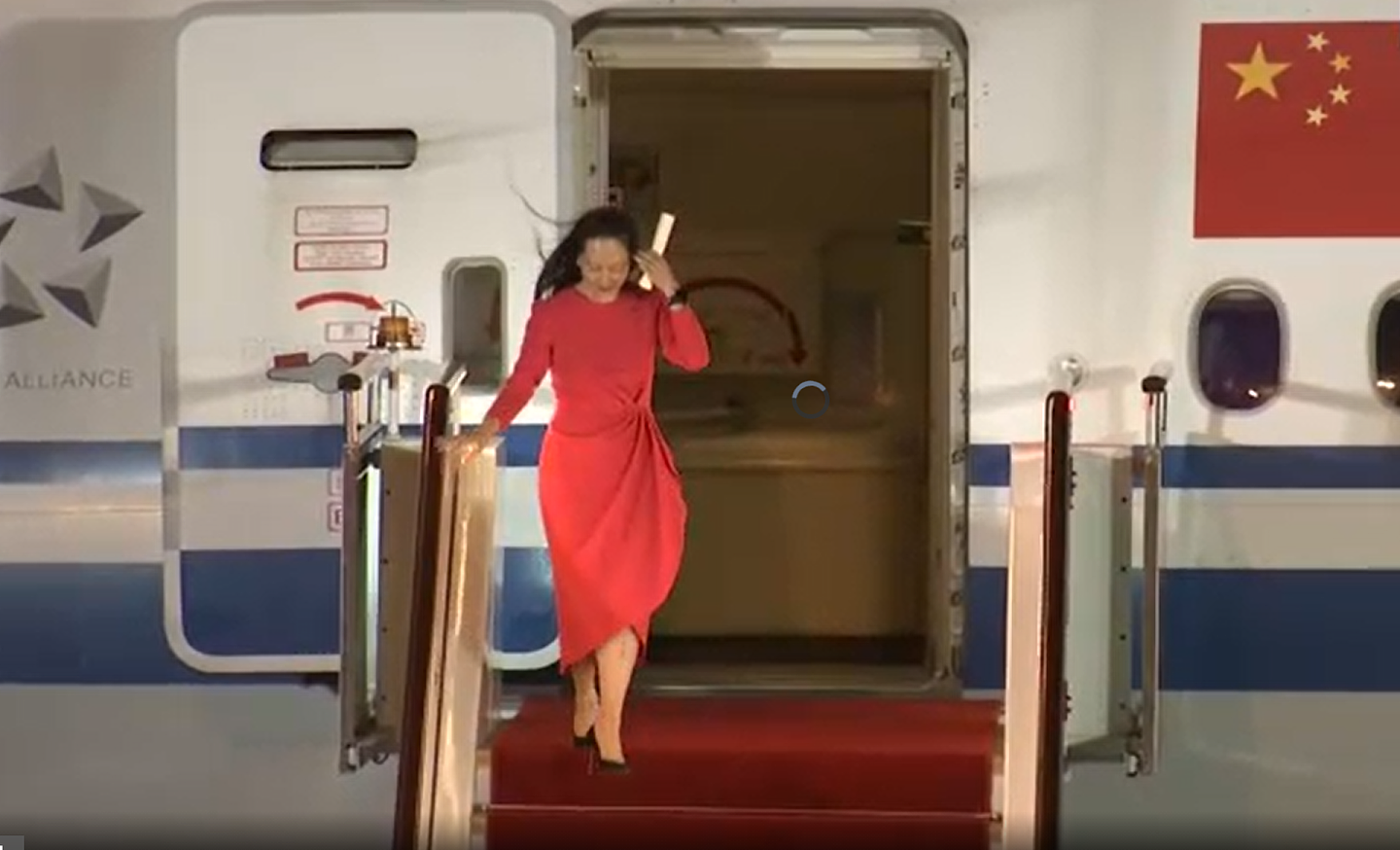 9月25日晚间，孟晚舟着红裙下飞机回到。（央视截图）