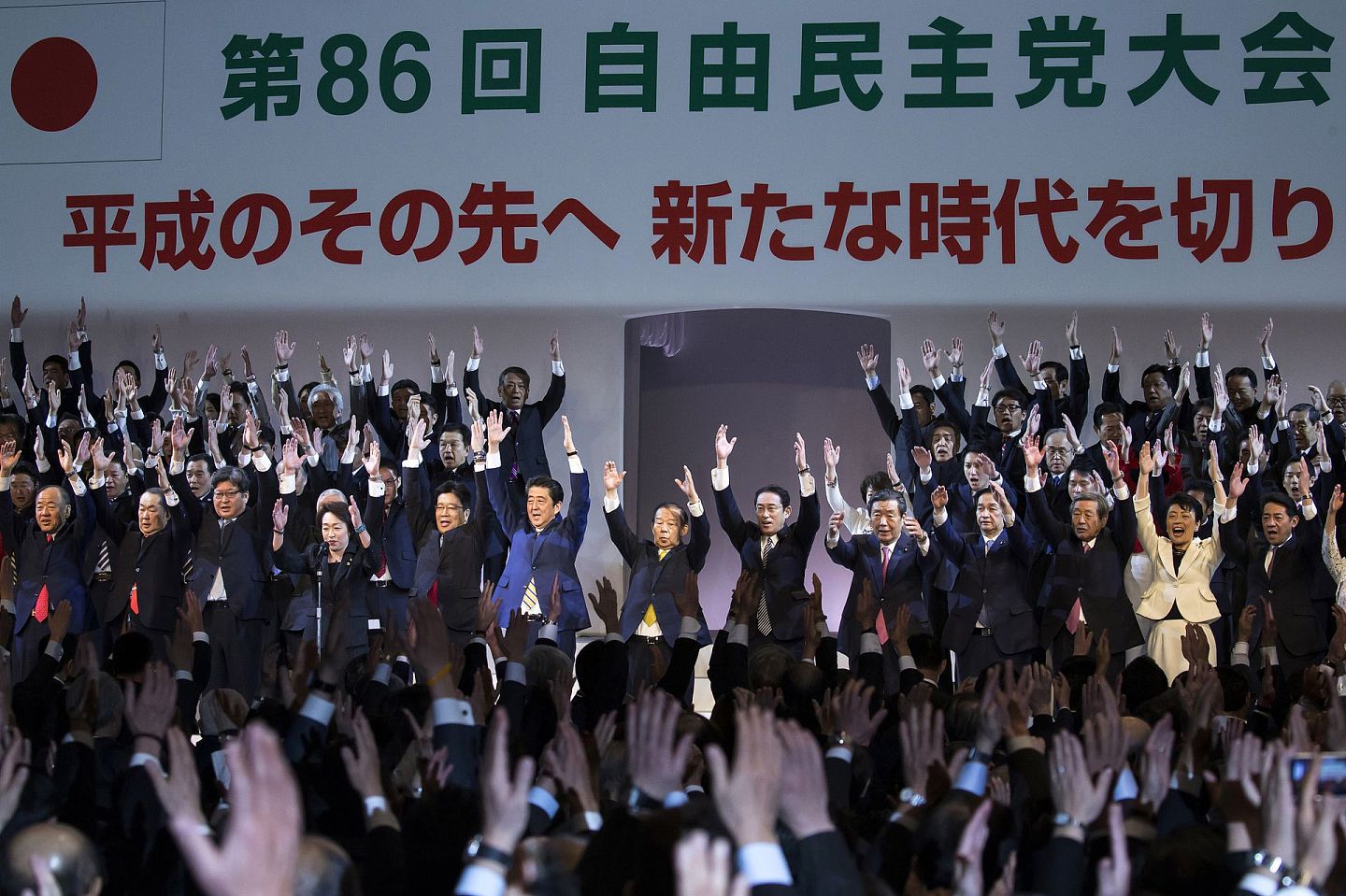自2012年日本众议院大选后，新一届众议院议员支援修宪的比例则高达89%，意味着日本已经具备修宪的条件。目前，日本各大政党对于是否赞成修宪、修宪的形式以及修宪的内容意见各不相同。图为日本首相兼自民党总统安倍晋三（左六）于当地时间2月10日的自民党年会上与其他党员一起欢呼。（图源：VCG）