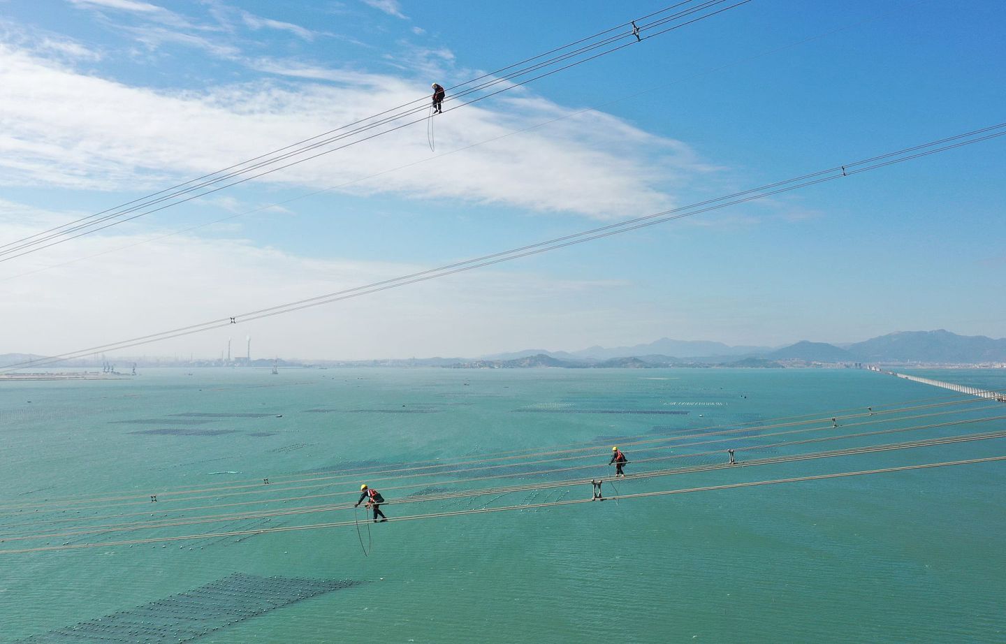 2020年11月13日，中国施工人员在百米高空跨海检修输电线路  。（新华社）