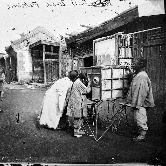 拉洋片艺人，使用的道具为四周安装有镜头的木箱（北京，1871-72年）。