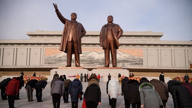 2021年2月，人们在朝鲜已故领导人金日成和金正日的雕像前鞠躬。