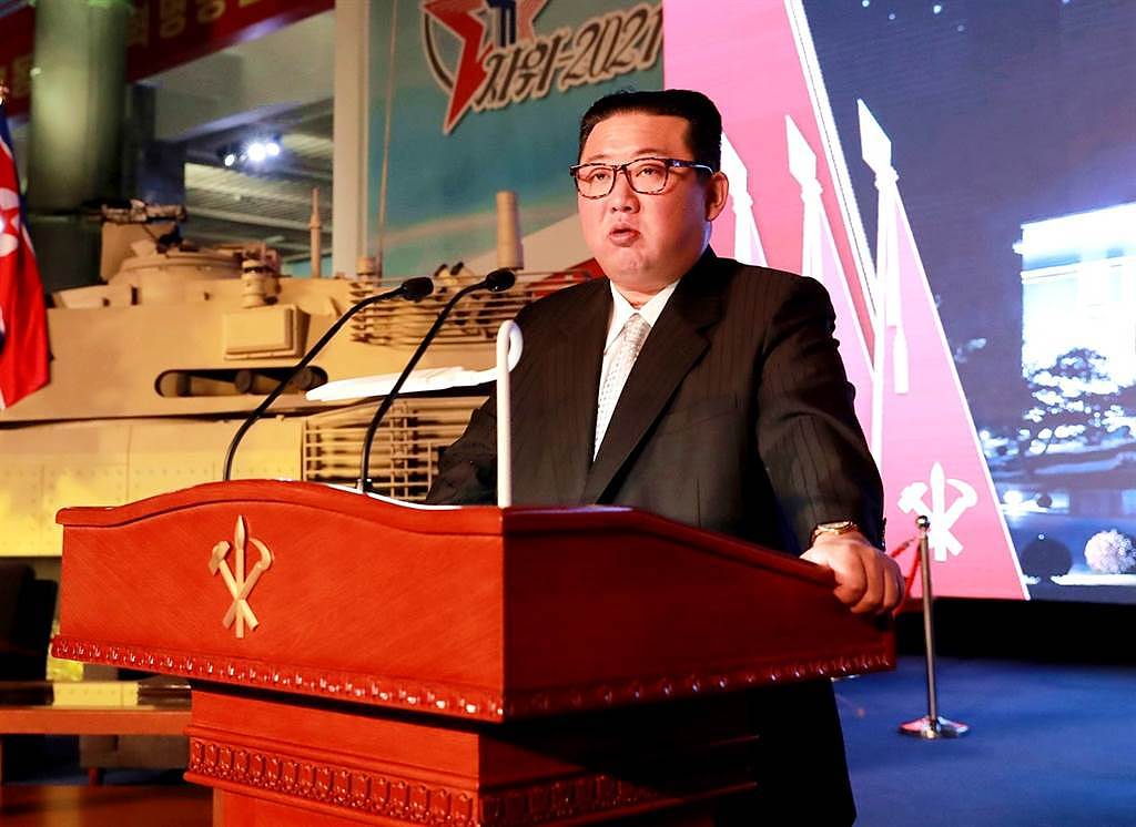 11日北韩国防展览会上，金正恩的风采被一名穿着亮蓝色紧身衣的男子抢走。 （图／路透社、北韩朝中社）