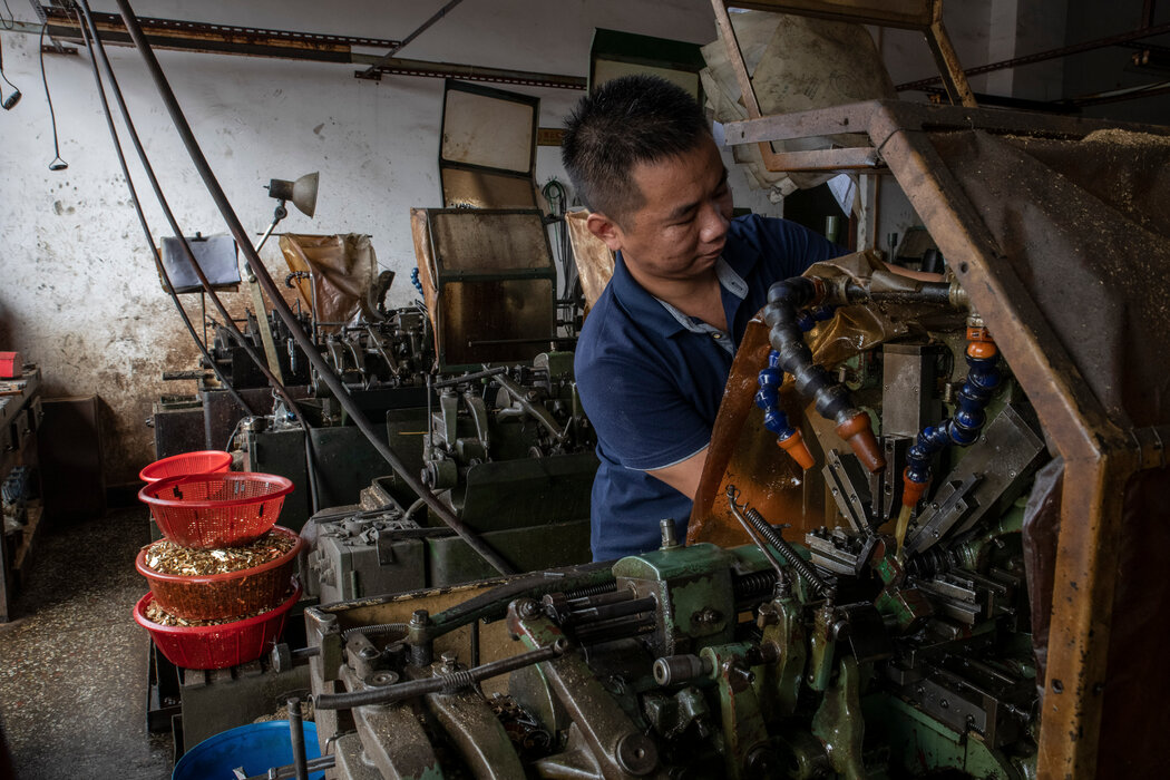 胡继彦（音）在他位于东莞的车间里制造小型机械零件。车间一直受到停电的困扰。