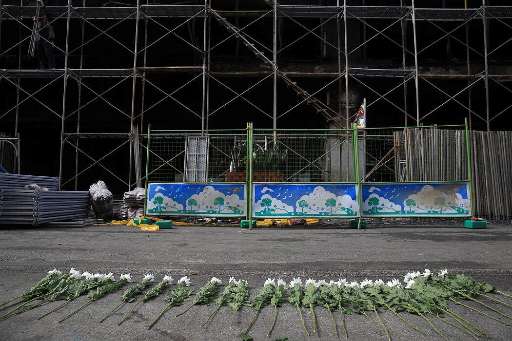 周五，台湾高雄，一幢13层高的大楼发生大火后，官员在楼前摆放了鲜花。