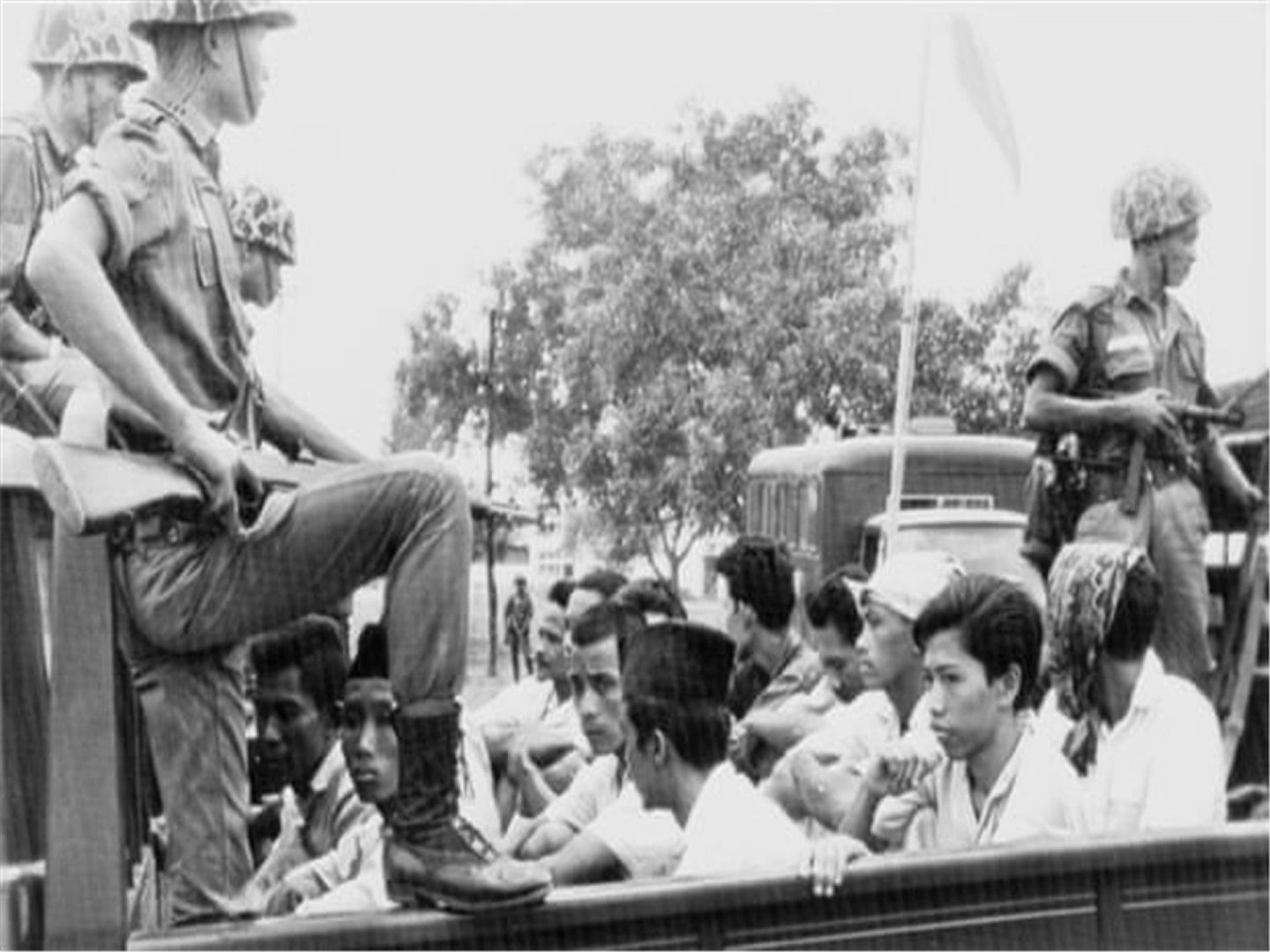 1965年10月，印尼共产党青年党成员在士兵的看守下，被敞篷卡车押送到雅加达监狱。（AP）