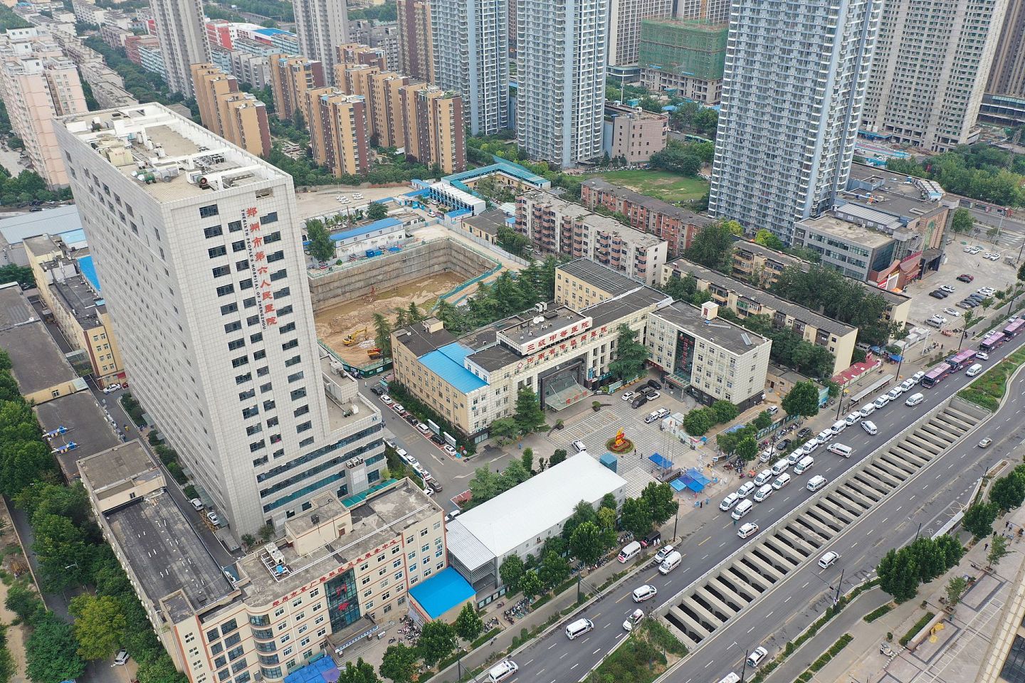 2021年8月5日，实拍郑州二七区京广路街道。郑州市第六人民医院航拍，门口停满了转运病人的救护车和大巴车。 （人民视觉）