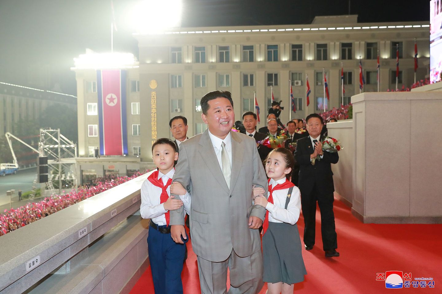 2021年9月9日，朝鲜庆祝建国73周年，朝鲜领袖金正恩当天深夜抵达位于平壤市中心的金日成广场，亲切地让两名儿童挽着他的手臂。（Reuters）