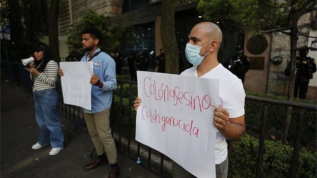 2021年10月12日，墨西哥城抗议者在西班牙大使馆外举着“种族灭绝”标语。