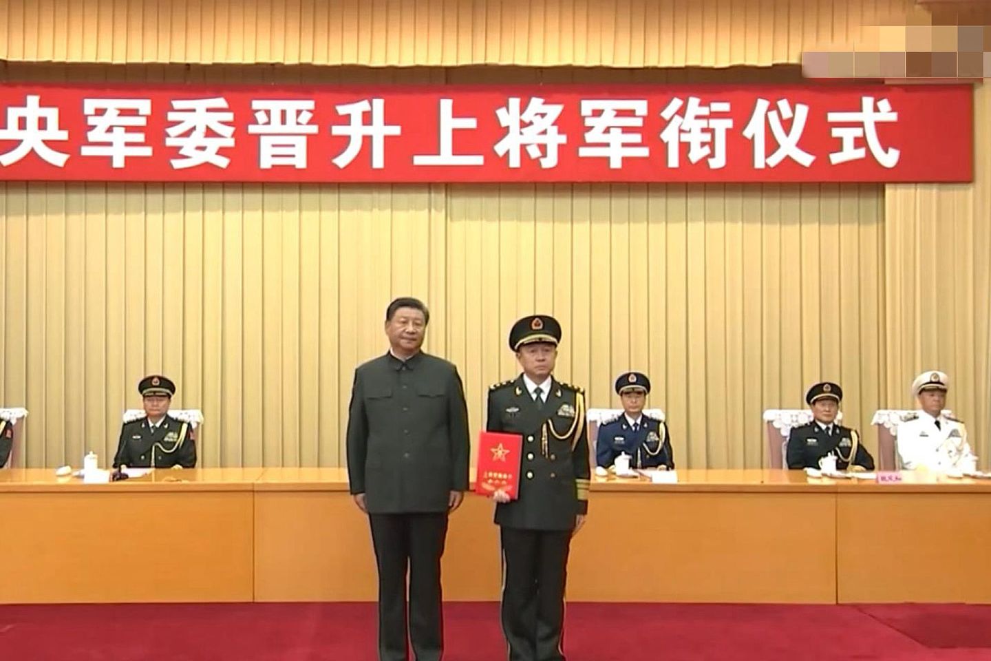 解放军西部战区司令在短时间内频繁换人。图为习近平（左）向汪海江（右）颁授上将军衔证书。（中国央视截图）