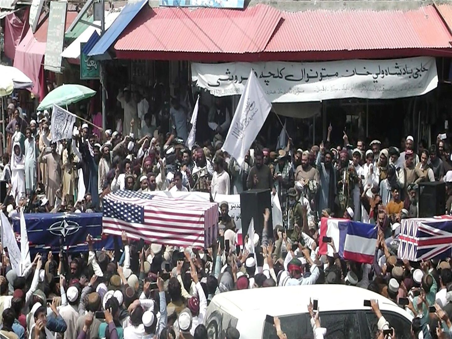 8月31日，塔利班在棺材上覆盖美英等国家的国旗，嘲讽这些国家在阿富汗的军事行动失败。（Twitter@BBCSalman）