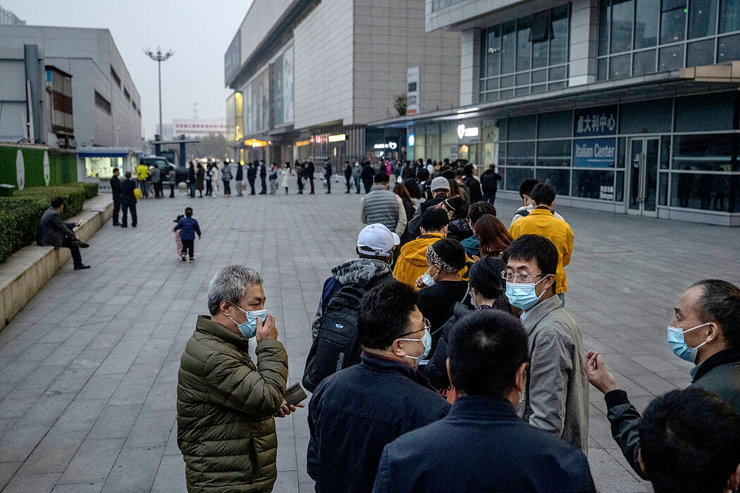 周一，人们在北京排队接受核酸检测，中国正在努力控制至少11个省和地区的新疫情。