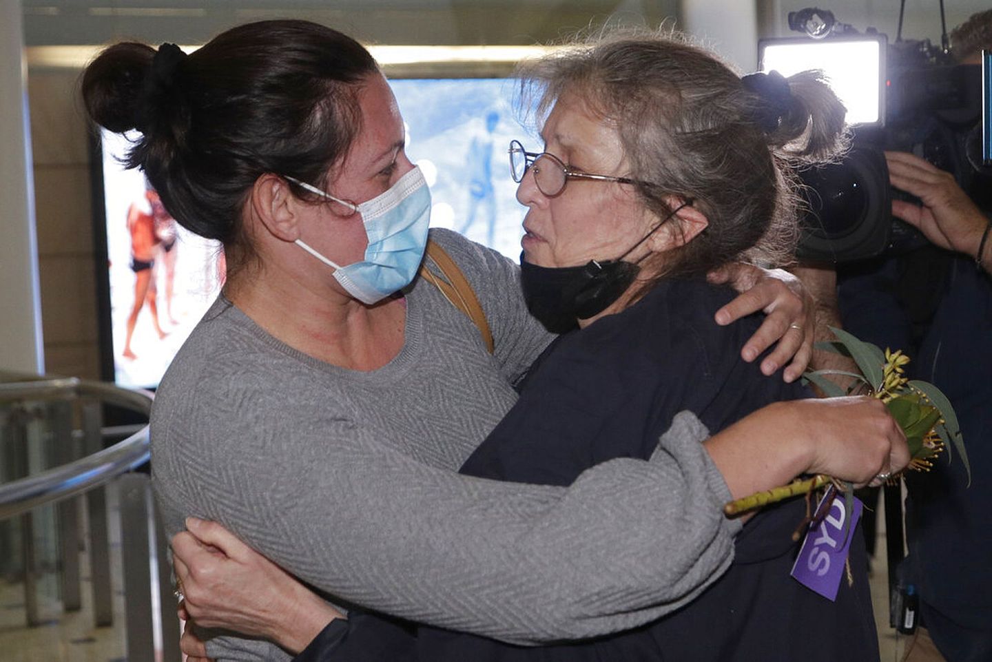 图为2021年11月1日，澳大利亚悉尼20个月以来第一次开放边境，两名女士在悉尼机场团聚后拥抱。（AP）