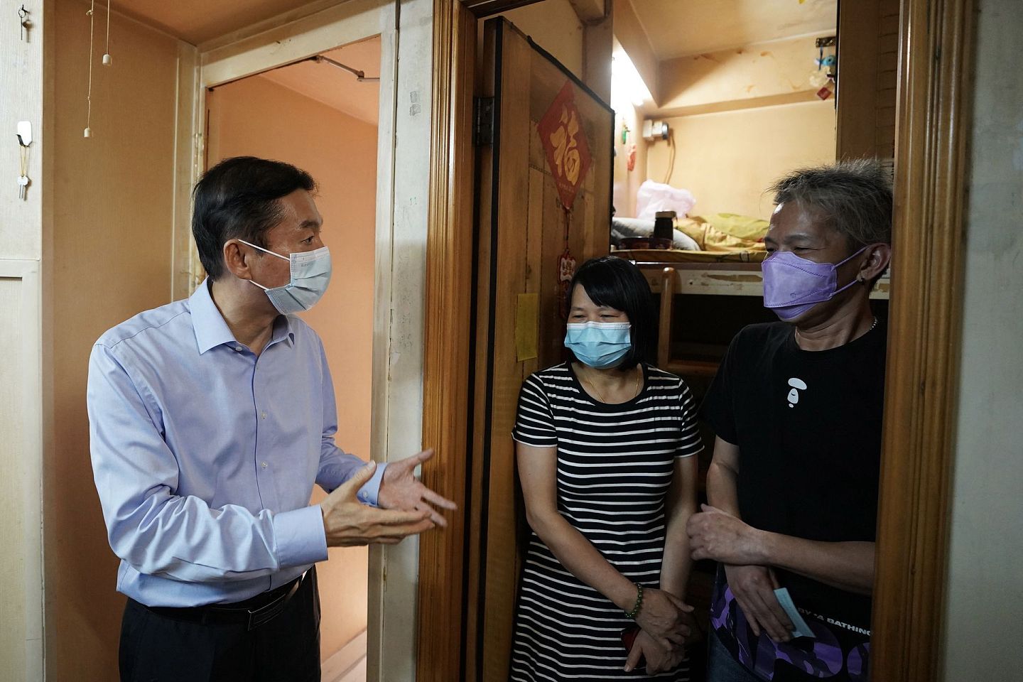 香港中联办主任骆惠宁（左）探访“笼屋”住户。（香港中联办供图）