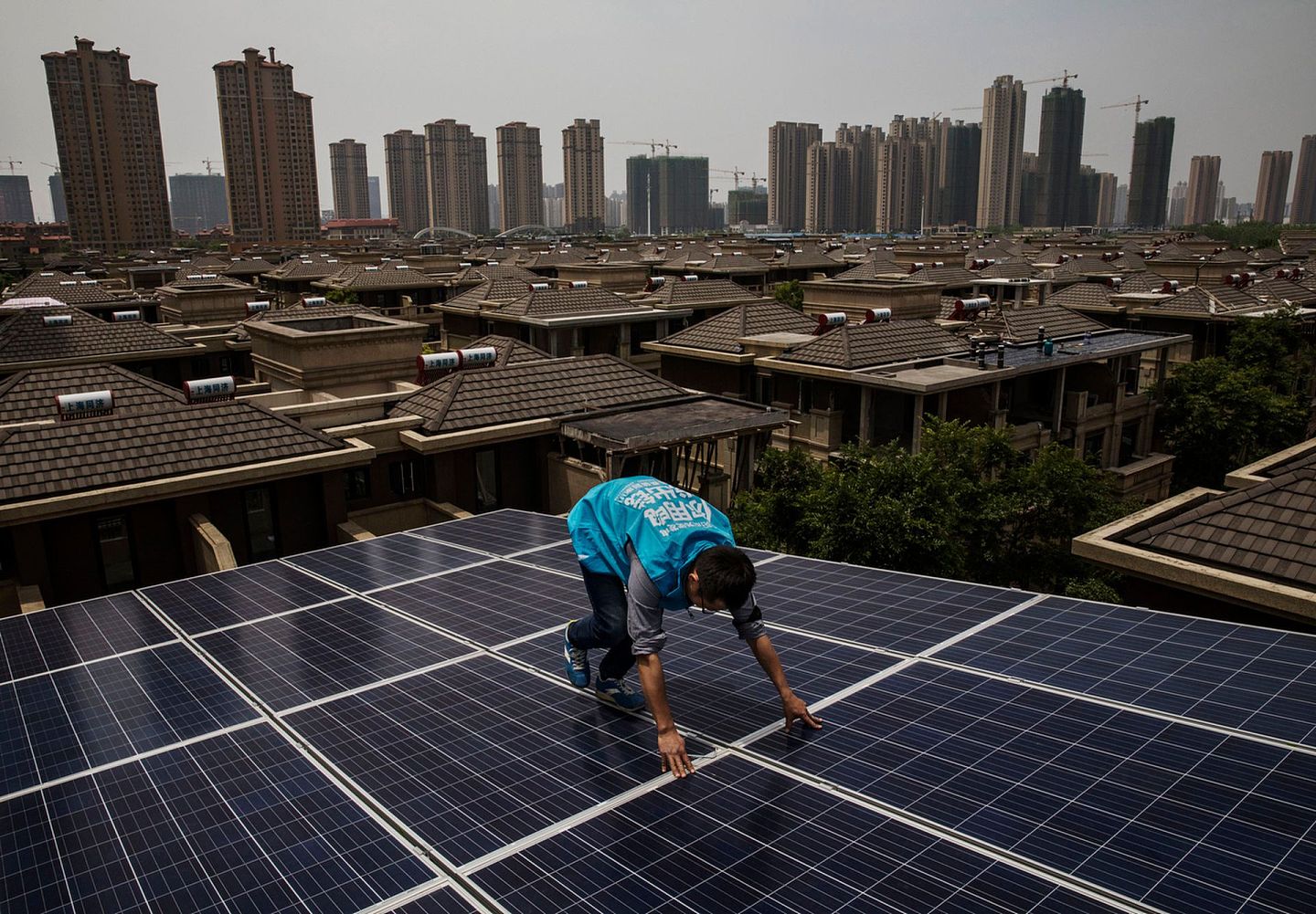 2017年4月27日，中国武汉市，一名工程人员在屋顶装设太阳能板。（Getty Images）