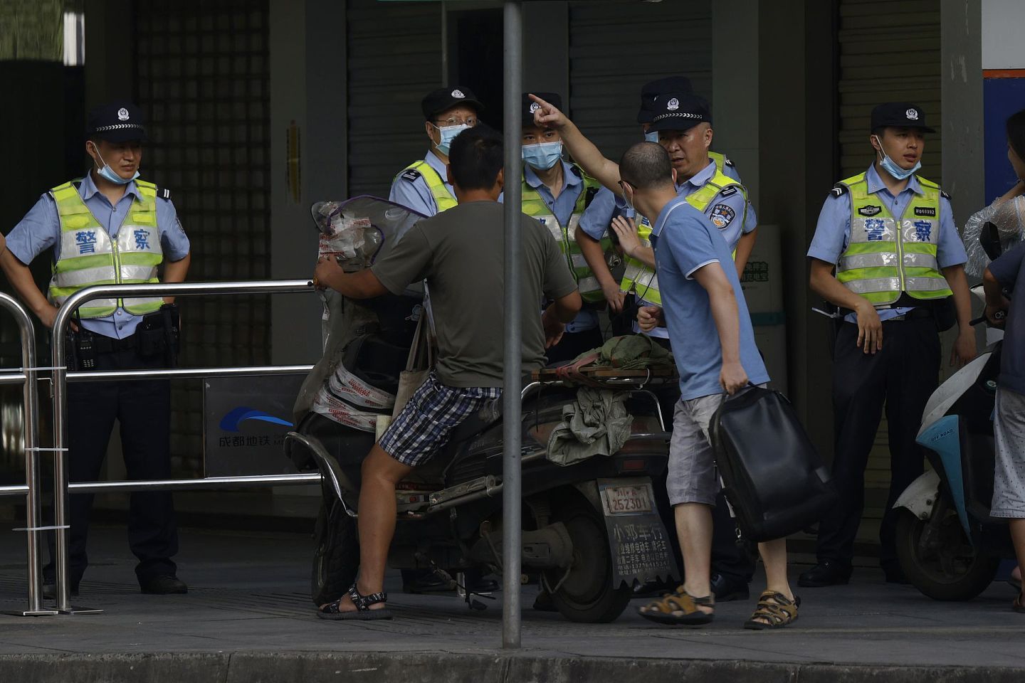 2020年7月27日，在美国驻成都总领事馆正式关闭之前，中国警察引导居民离开一个被封锁的社区。中方主管部门随后从正门进入，实行接管。（AP）
