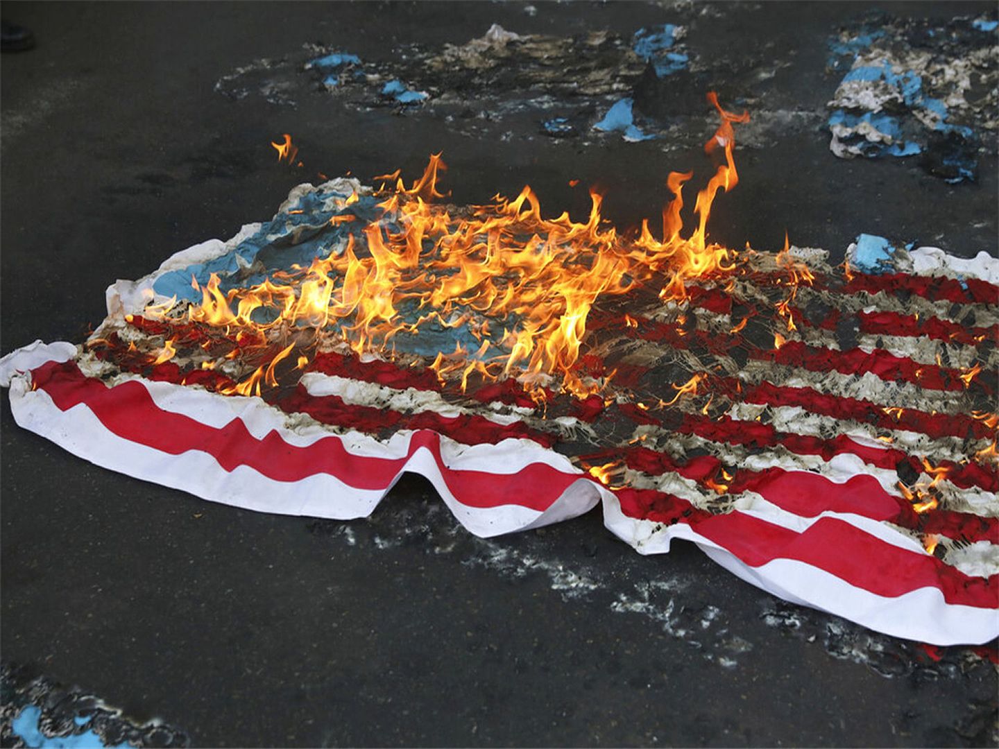 11月4日，示威者们在美国前驻伊使馆前，焚烧美国国旗。（AP）