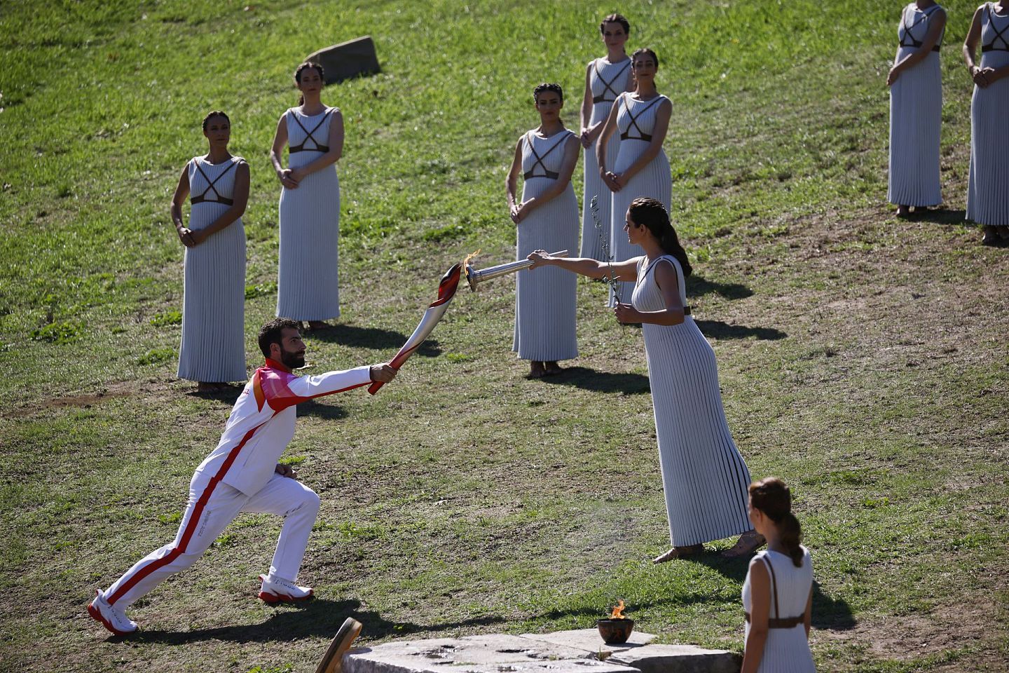 扮演女祭司的演员将圣火传递给第一个火炬手希腊滑雪运动员安东尼奥。（Reuters）