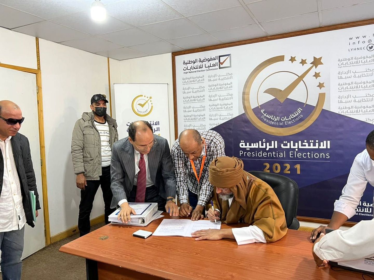 图为2021年11月14日，利比亚已故前领袖卡扎菲次子赛义夫（穿啡巡者）在该国南部小镇塞卜哈登记为该国总统选举的候选人，参加12月24日举行的大选。（Reuters）