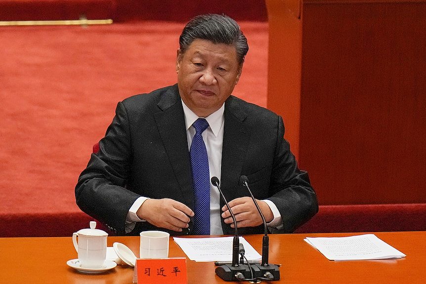 Xi Jinping sitting down before speaking at the Great Hall of the People. 