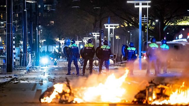 Policemen stand near burning objects after a protest against the 