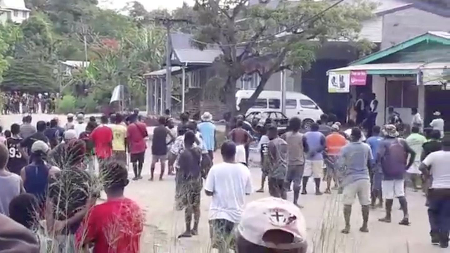 图为11月25日，所罗门群岛政府在首都霍尼亚拉颁布宵禁期间，示威者违抗封城令，在当地一间警署附近聚集。（AP）