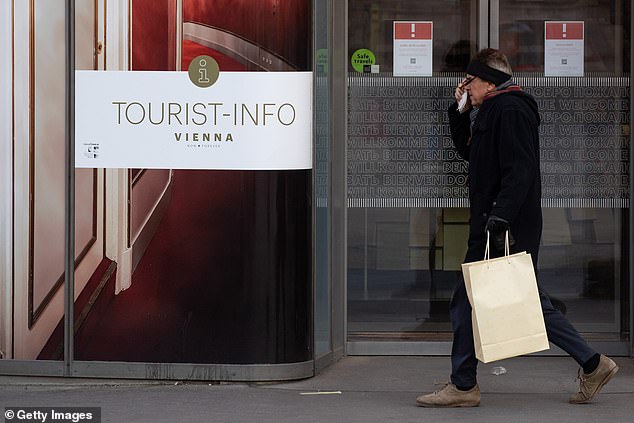 More than 4,000 are dying every day across Europe at the moment with Russia, Germany, Romania, Poland, Austria and the Netherlands among the worst hit (pictured, a man walks past a closed tourist information office in Austria during the fresh lockdown)