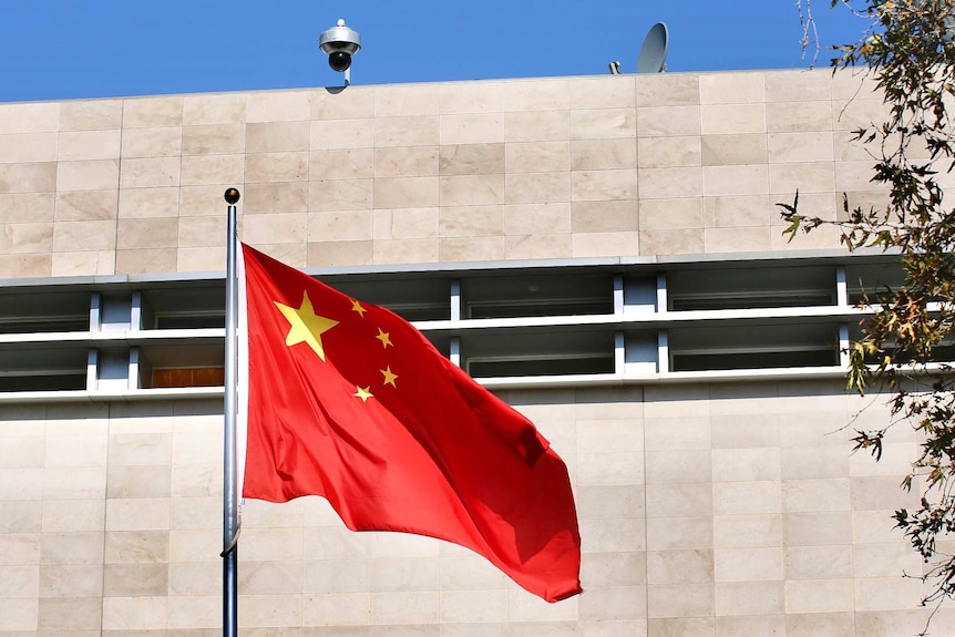 A Chinese flag flutters in wind before the Chinese Consulate building in East Perth on a sunny day.