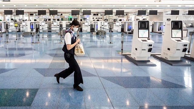 日本东京羽田机场一位工作人员走过已关闭的值机柜台（22/5/2021）