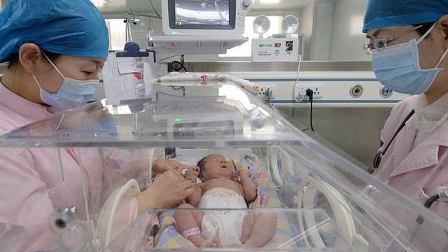河北省邯郸市一家医院的护士在保育箱里照顾新生儿。