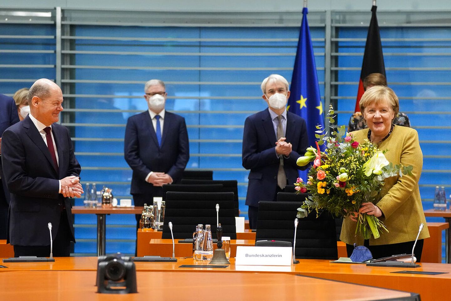 在11月24日的内阁会议上，下任德国总理萧尔茨（左）向默克尔送花。（AP）