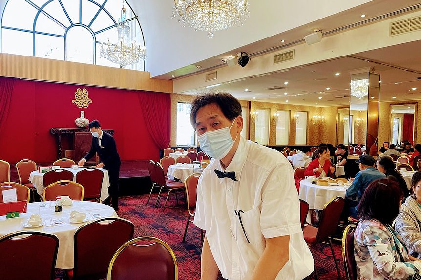 An Asian waiter who wearing a mask