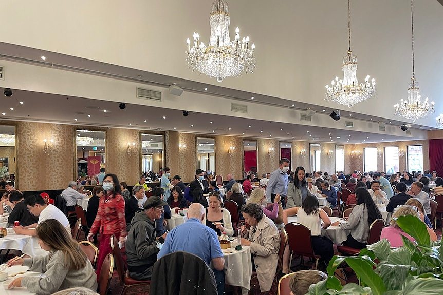 A fancy banquet hall full of customers.