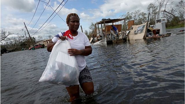 飓风过后，妇女用袋子装着自己的东西