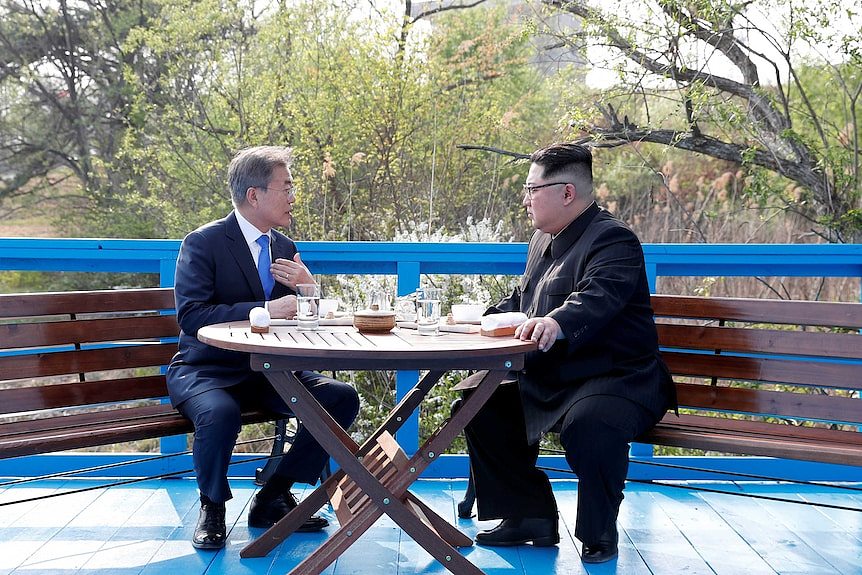 South Korean President Moon Jae-in and North Korean leader Kim Jong Un sit together.