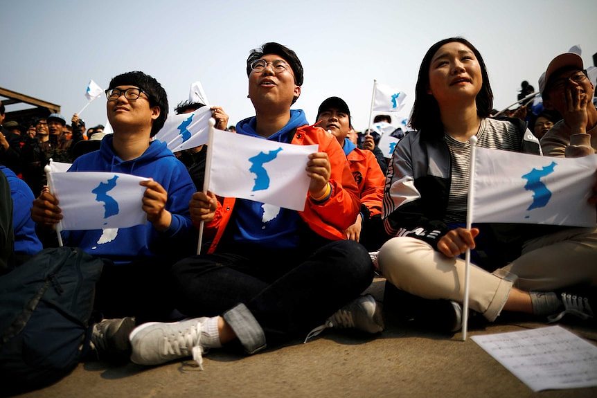 People hold the Korean unification flag.