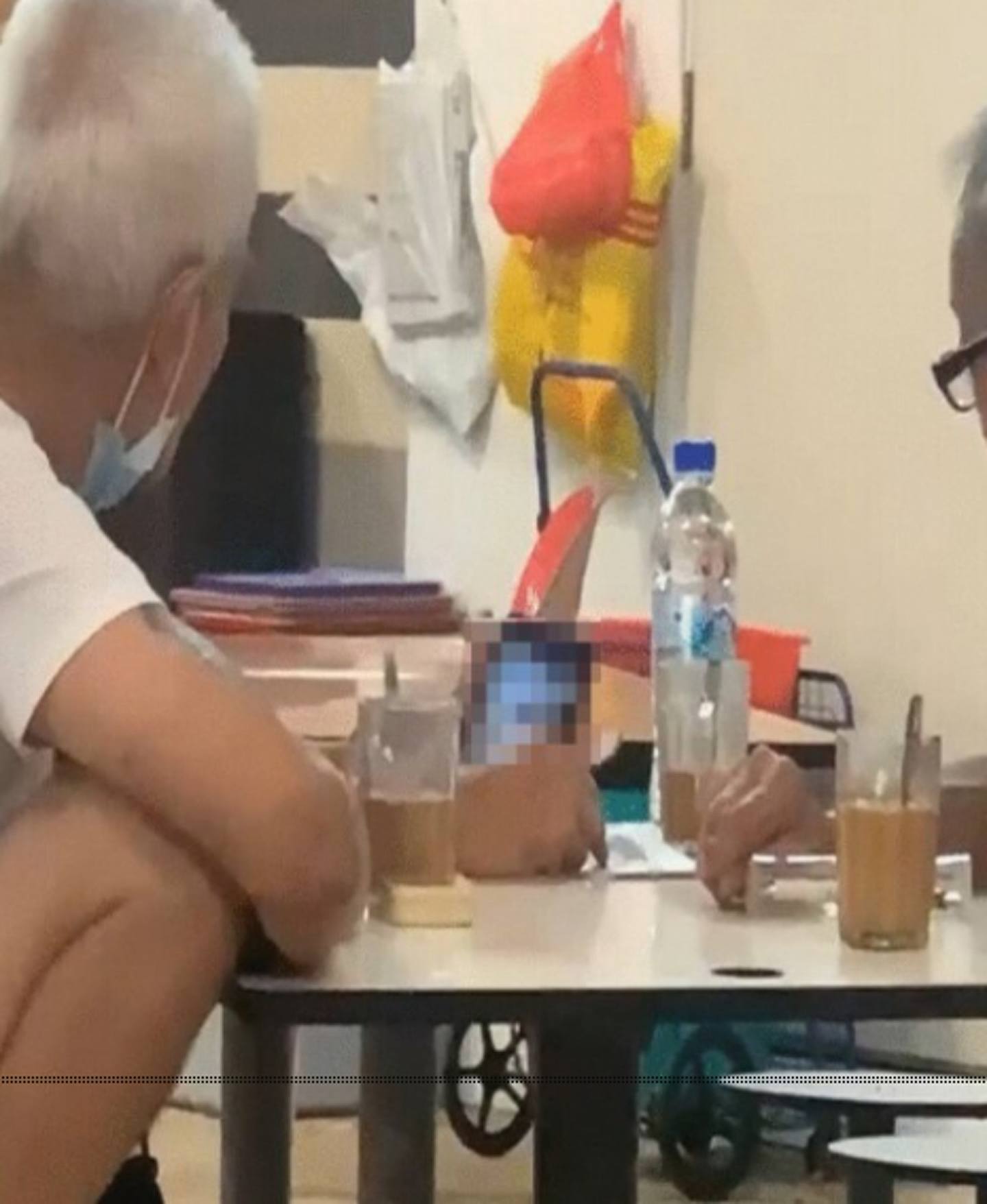 新加坡3名銀髮伯伯公然在熟食市場，用手機觀賞成人片段，據稱曾有途人上前勸喻，但還是繼續全心欣賞。（影片截圖）